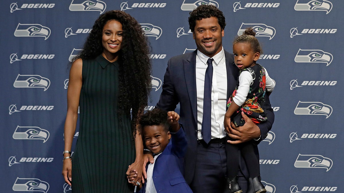 Seattle Seahawks NFL football quarterback Russell Wilson poses for photos with his wife Ciara, their daughter Sienna, and Ciara's son Future, Wednesday, April 17, 2019, in Renton, Wash., following a press conference. Earlier in the week, Wilson signed a $140 million, four-year extension with the team. (AP Photo/Ted S. Warren)