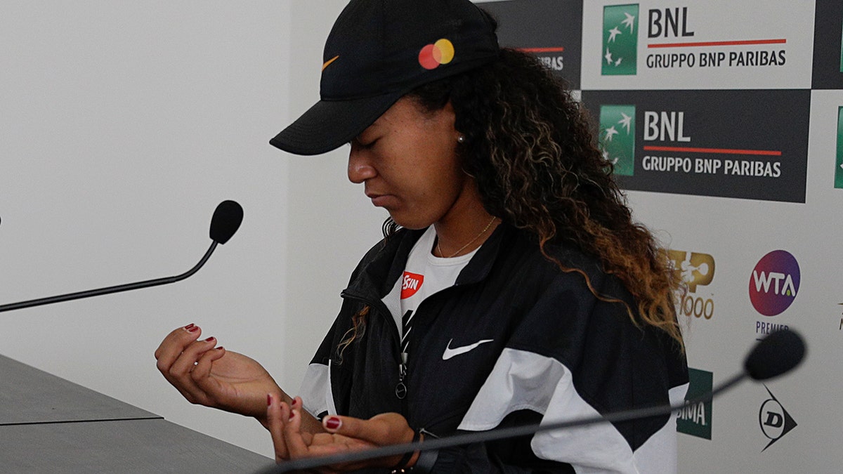 Japan's Naomi Osaka shows her hands as she meets the journalists at the Italian Open tennis tournament, in Rome, Friday, May, 17, 2019. Top-ranked Naomi Osaka withdrew from her Italian Open quarterfinal due to a right hand injury on Friday. It wasn't immediately clear how serious the injury was, or if it will affect Osaka's status for the French Open, which starts in nine days. (AP Photo/Gregorio Borgia)