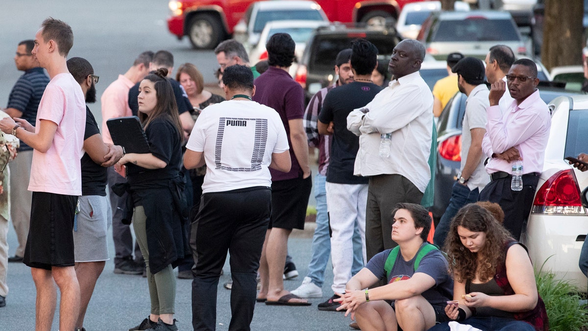 People gather across from the campus of UNC Charlotte after a shooting incident at the school Tuesday, April 30, 2019, in Charlotte, N.C.