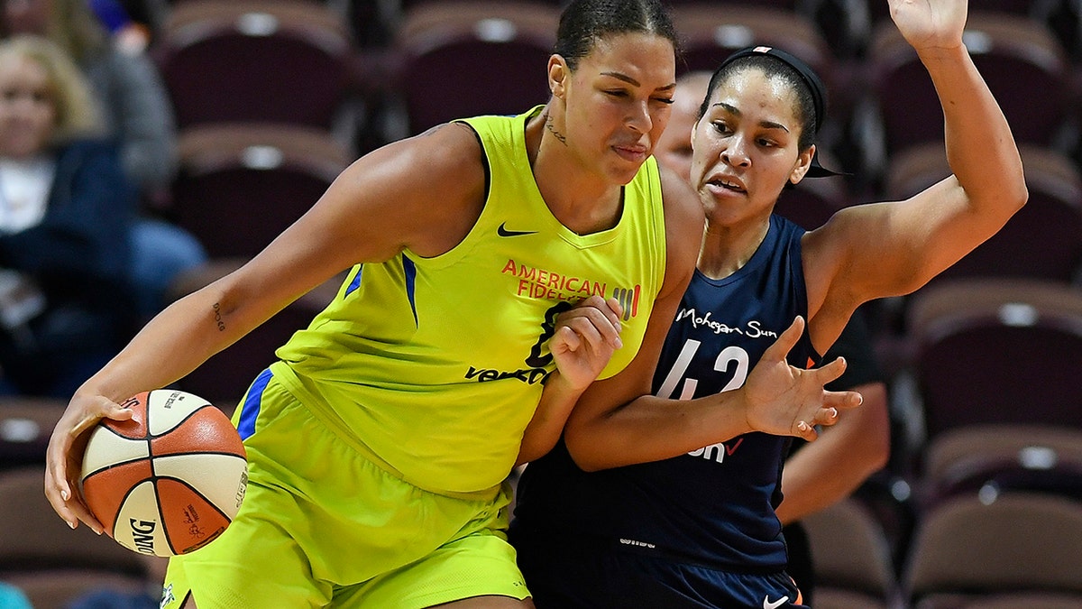  Dallas Wings' Liz Cambage, left, drives against Connecticut Sun's Brionna Jones during a preseason WNBA basketball game in Uncasville, Conn. (AP Photo/Jessica Hill, File)