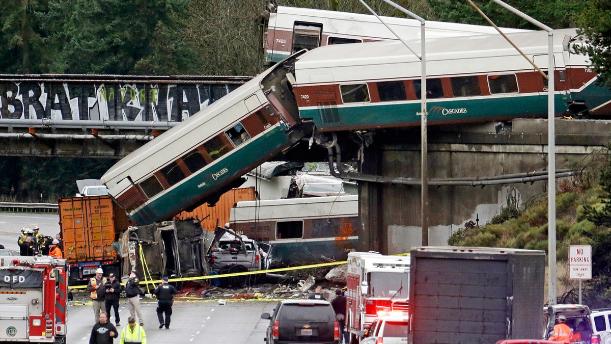 In this Dec. 18, 2017, file photo, cars from an Amtrak train lay spilled onto Interstate 5 alongside smashed vehicles as some train cars remain on the tracks above in DuPont, Wash.