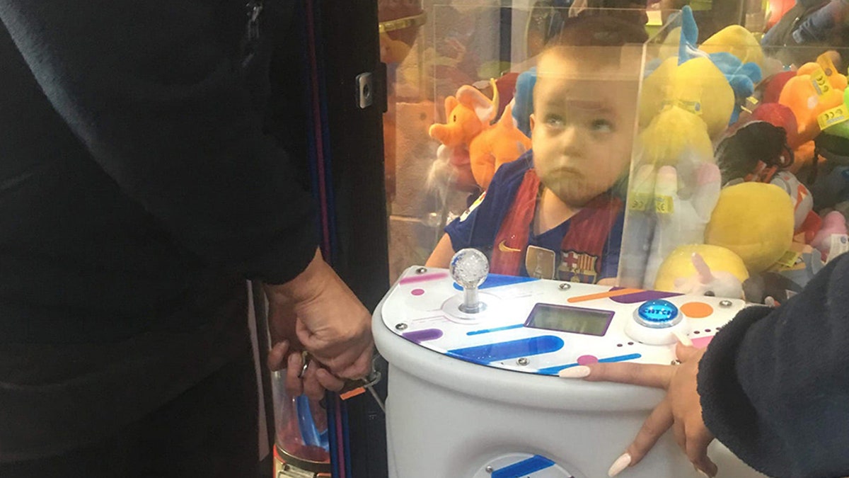A mother-of-three was left in hysterics after finding her son Noah, pictured, had climbed into a toy arcade machine in hopes of nabbing a teddy bear.