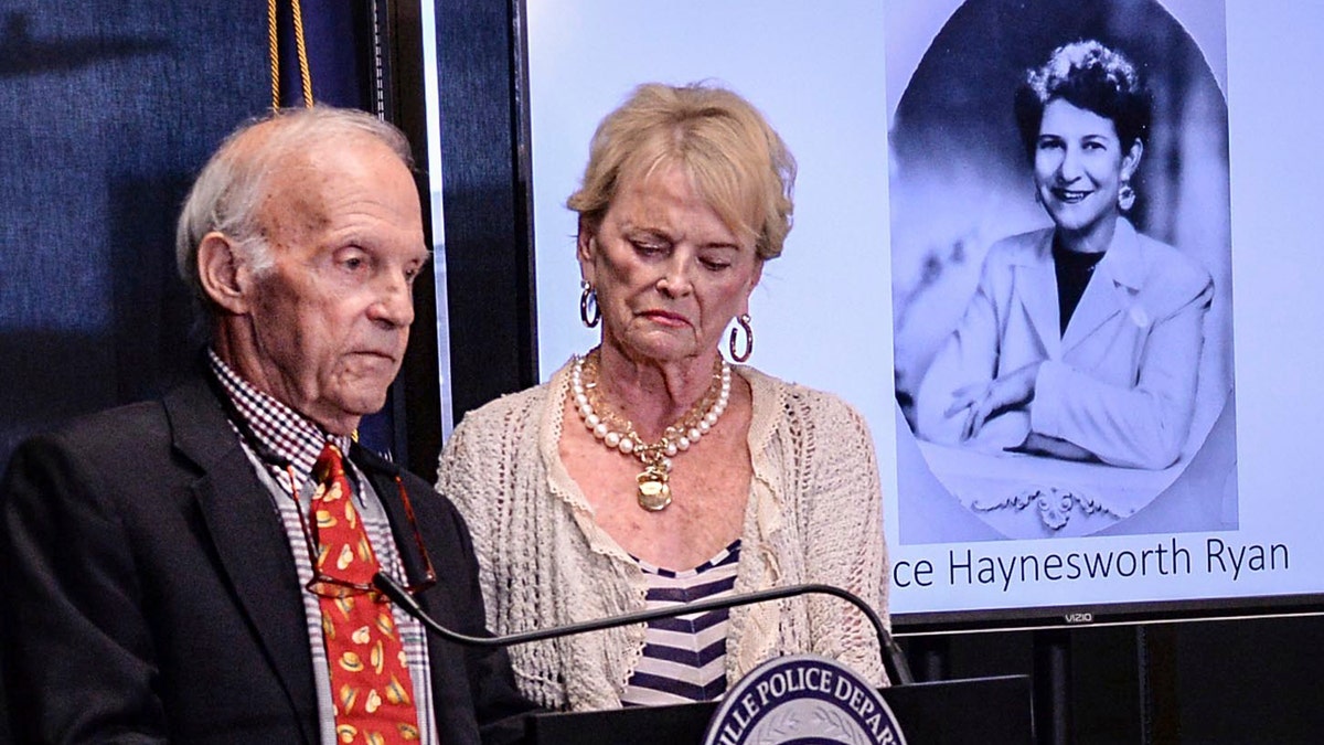 Joe Ryan, left, of Greenville stands with his wife near a photo of his late mother Alice Haynesworth Ryan, during a city police announcement of an arrest in the 1988 cold case homicide.