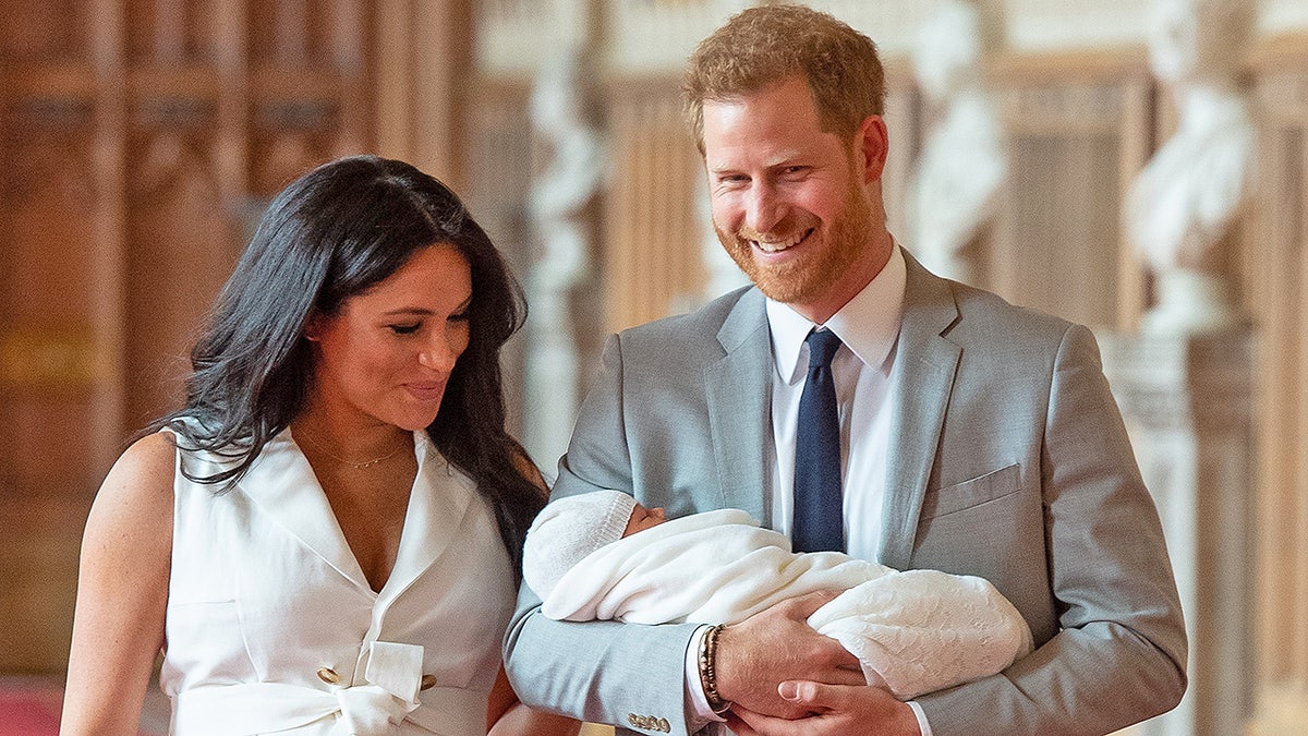 Britain's Prince Harry, Duke of Sussex (R), and his wife Meghan, Duchess of Sussex, pose for a photo with their newborn baby son in St George's Hall at Windsor Castle in Windsor, west of London on May 8, 2019. (Photo by Dominic Lipinski / POOL / AFP)        (Photo credit should read DOMINIC LIPINSKI/AFP/Getty Images)