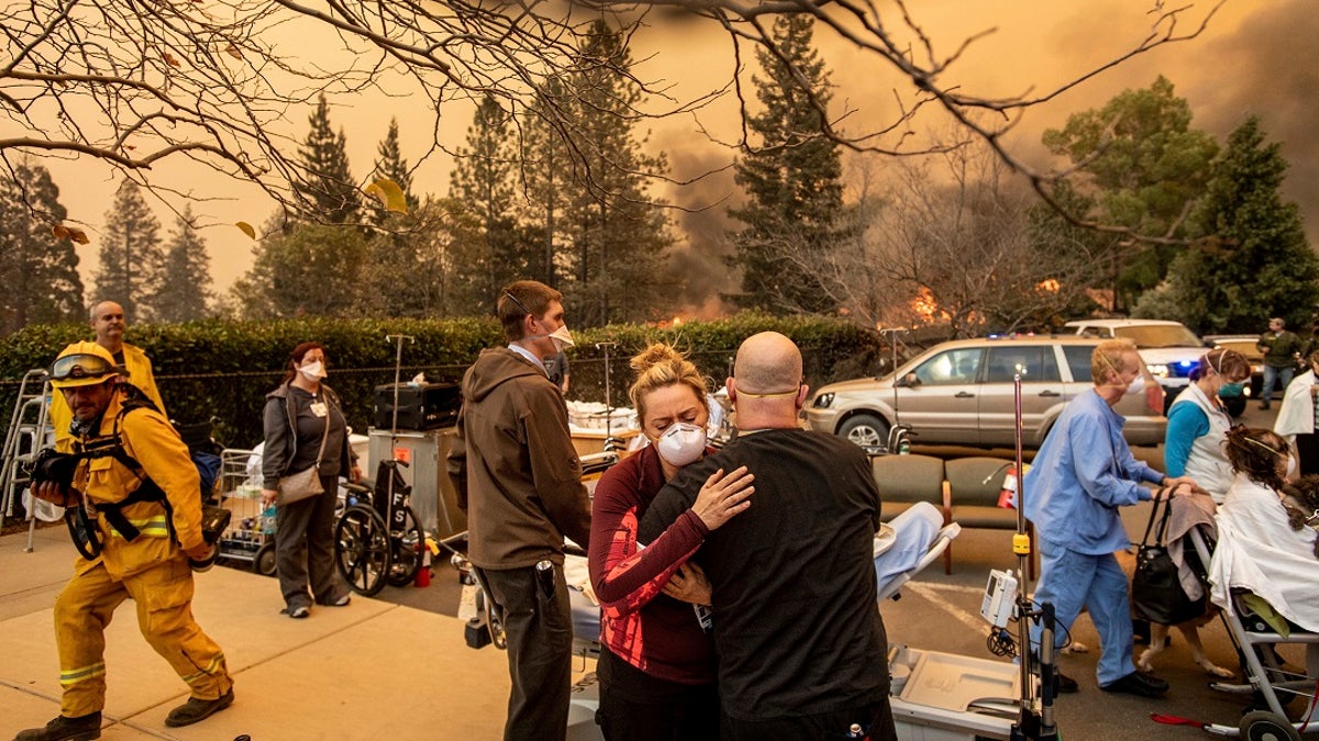 This Nov. 8 photo shows Nurse Cassie Lerossignol hugging a co-worker as the Feather River Hospital burns, victim of the Camp Fire raging in Paradise, Calif. (AP Photo/Noah Berger, File)