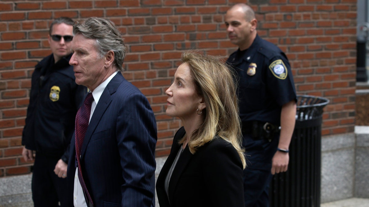Actress Felicity Huffman arrives with her brother Moore Huffman Jr., at federal court Monday, May 13, 2019, in Boston, where she is scheduled to plead guilty to charges in a nationwide college admissions bribery scandal. (AP Photo/Steven Senne)