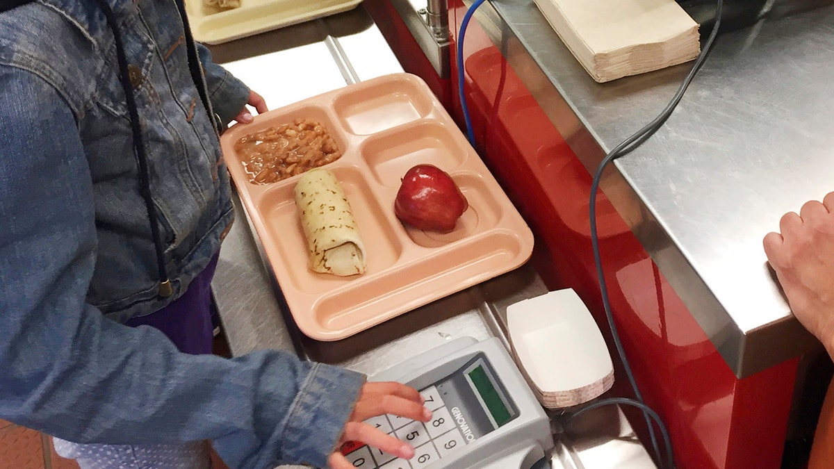 In this Thursday, May 4, 2017 photo, a third-grader punches in her student identification to pay for a meal at Gonzales Community School in Santa Fe, N.M.