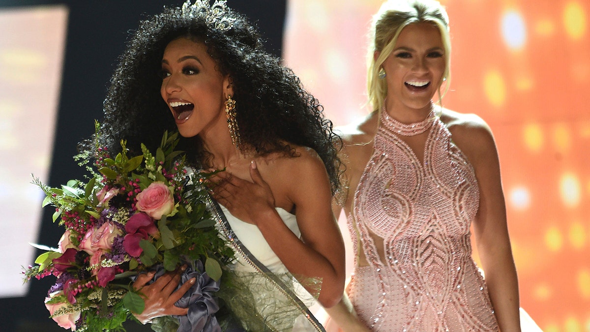 Miss North Carolina Cheslie Kryst, left, gets crowned by last year's winner Sarah Rose Summers, right, after winning the 2019 Miss USA final competition in the Grand Theatre in the Grand Sierra Resort in Reno, Nev., on Thursday, May 2, 2019. Kryst, a 27-year-old lawyer from North Carolina who represents some prison inmates for free, won the 2019 Miss USA title Thursday night in a diverse field that included teachers, nurses and members of the military. (Jason Bean/The Reno Gazette-Journal via AP)