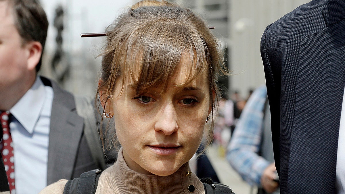 FILE- In this April 8, 2019 file photo, actress Allison Mack leaves Brooklyn federal court in New York after pleading guilty to racketeering charges in a case involving a cult-like group based in upstate New York called NXIVM. Some speculate that Mack may take the witness stand to testify against Keith Raniere, the group's one-time leader who is facing federal charges of forming a secret society within his organization that forced women to have sex with him. (AP Photo/Mark Lennihan, File)