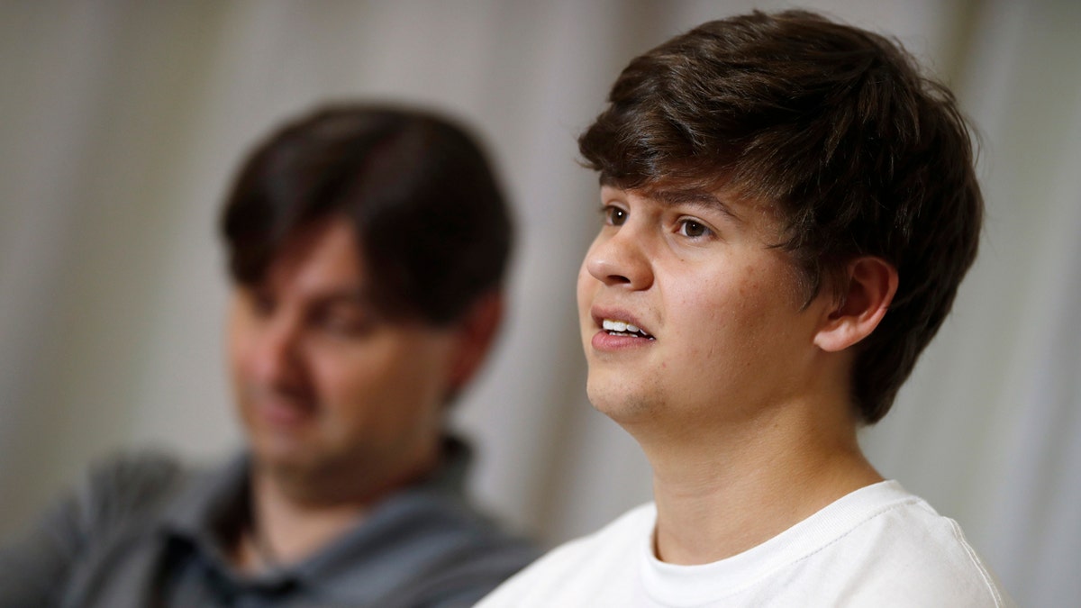 Joshua Jones, front, who was wounded while trying to stop a gunman involved in the attack on the STEM School Highlands Ranch last week, speaks during a news conference.