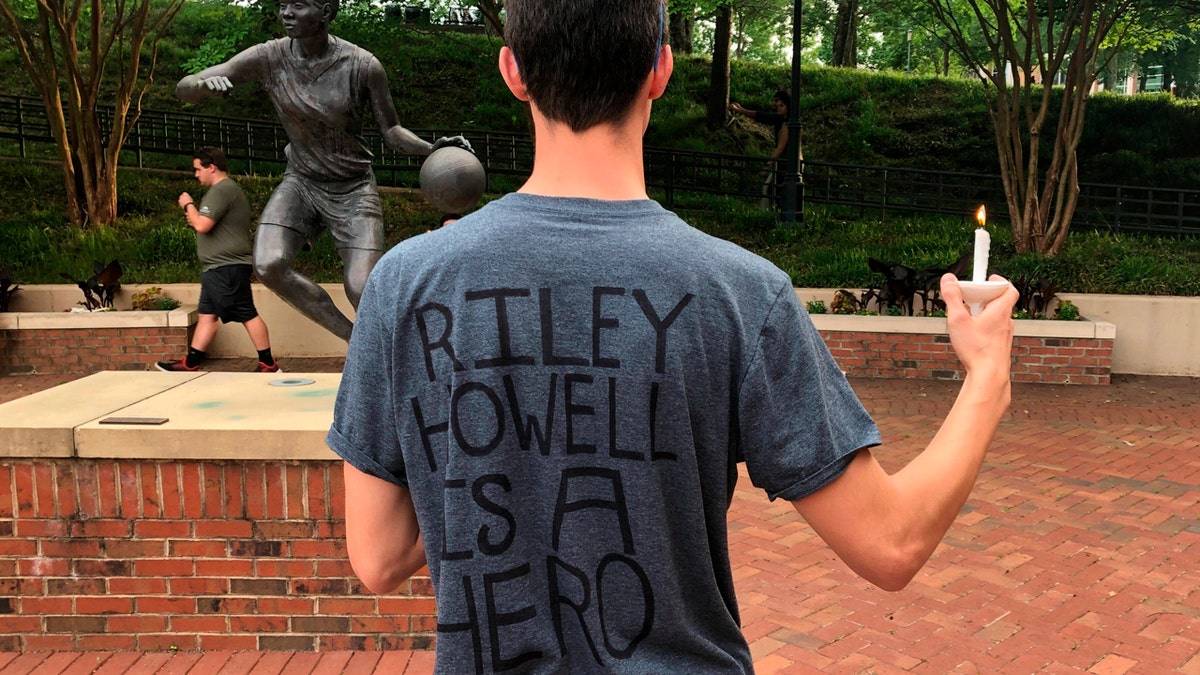 David Belnap, a sophomore at the University of North Carolina at Charlotte, displays a t-shirt in Charlotte, N.C., Wednesday, May 1, 2019, in support of Riley Howell, a classmate who was killed while confronting a gunman inside a classroom on Tuesday.
