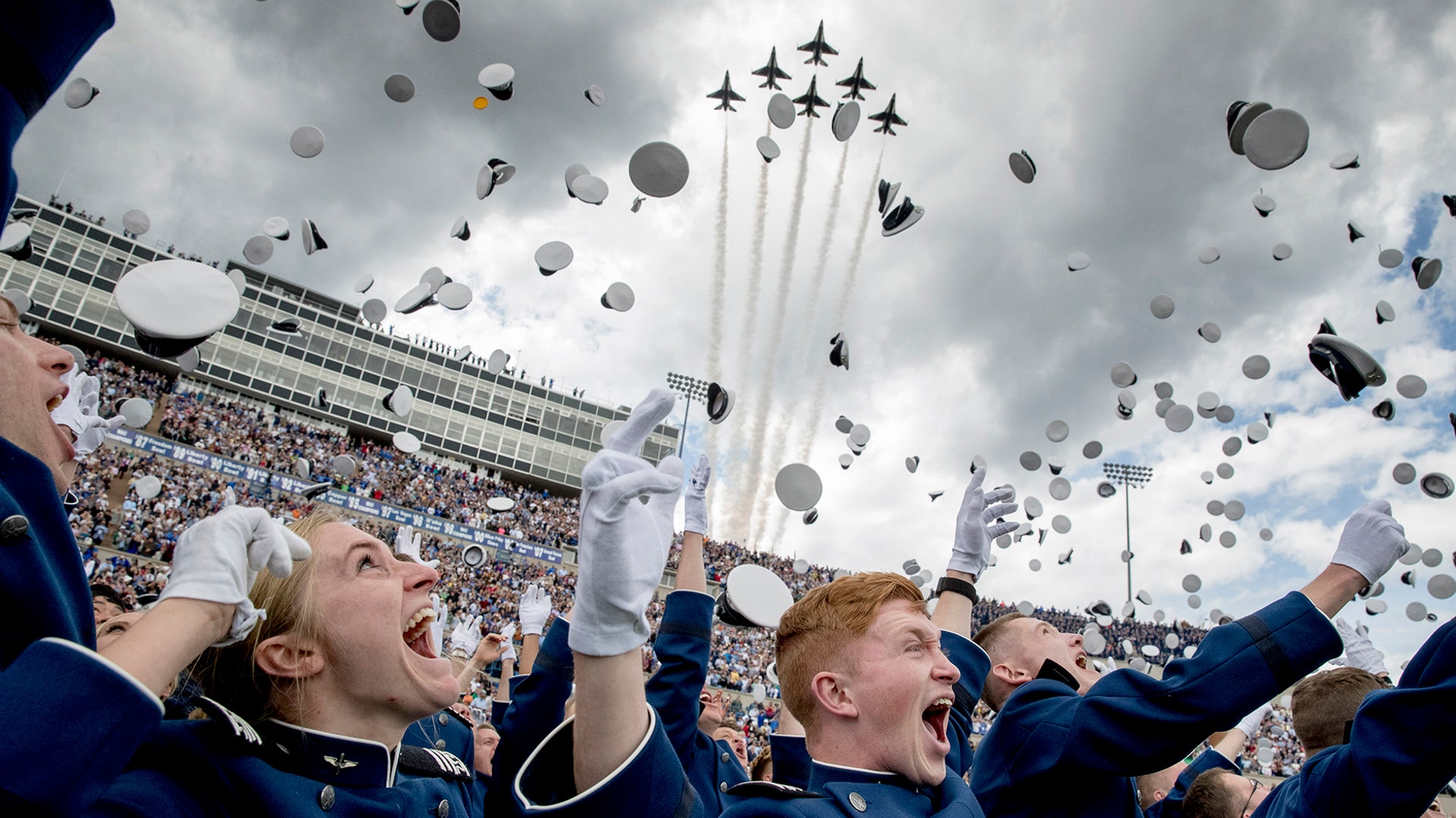 United States Air Force Academy cadets toss their hats in the air as the Thunderbirds fly overhead during the cadets' graduation ceremony at Falcon Stadium in Colorado Springs, Colorado, May 30, 2019. 