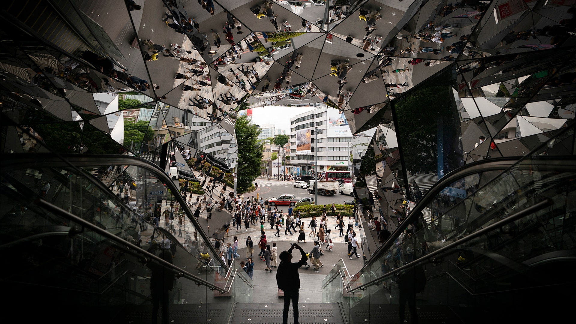 A tourist takes pictures in the entrance way to a shopping mall decorated with mirrors in Tokyo, May 18, 2019.