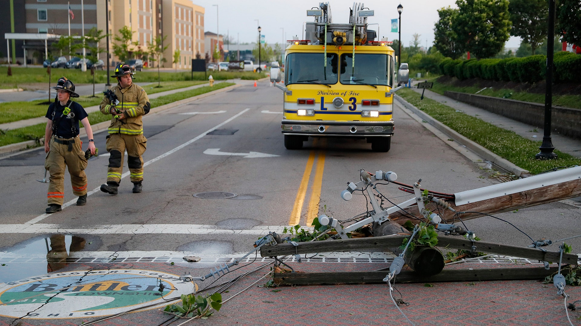 Firefighters look at downed power lines in a residential neighborhood in Vandalia, Ohio, May 28, 2019.