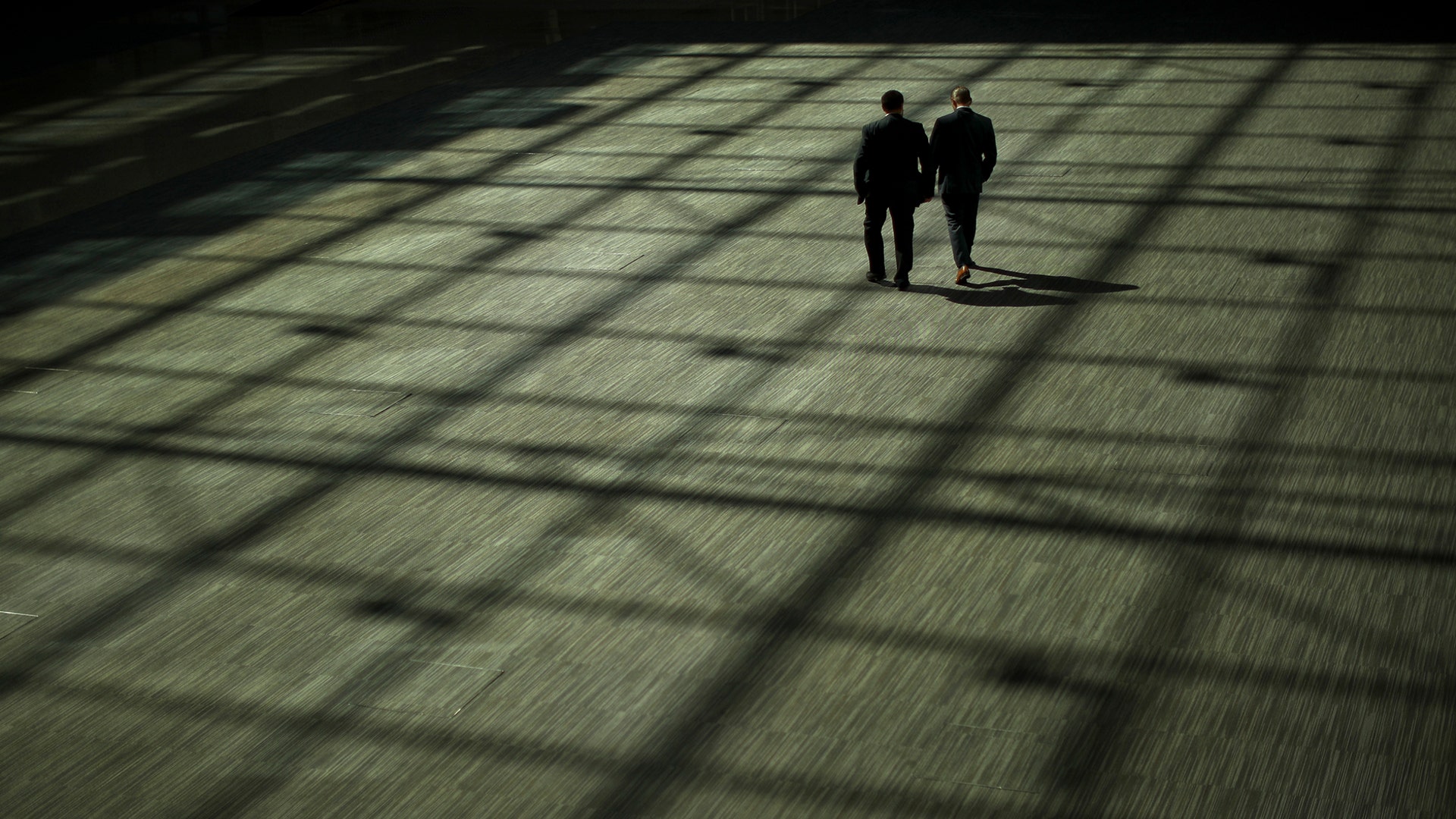 Two men walk along in the main atrium of the EU Council headquarters in Brussels, May 13, 2019. 