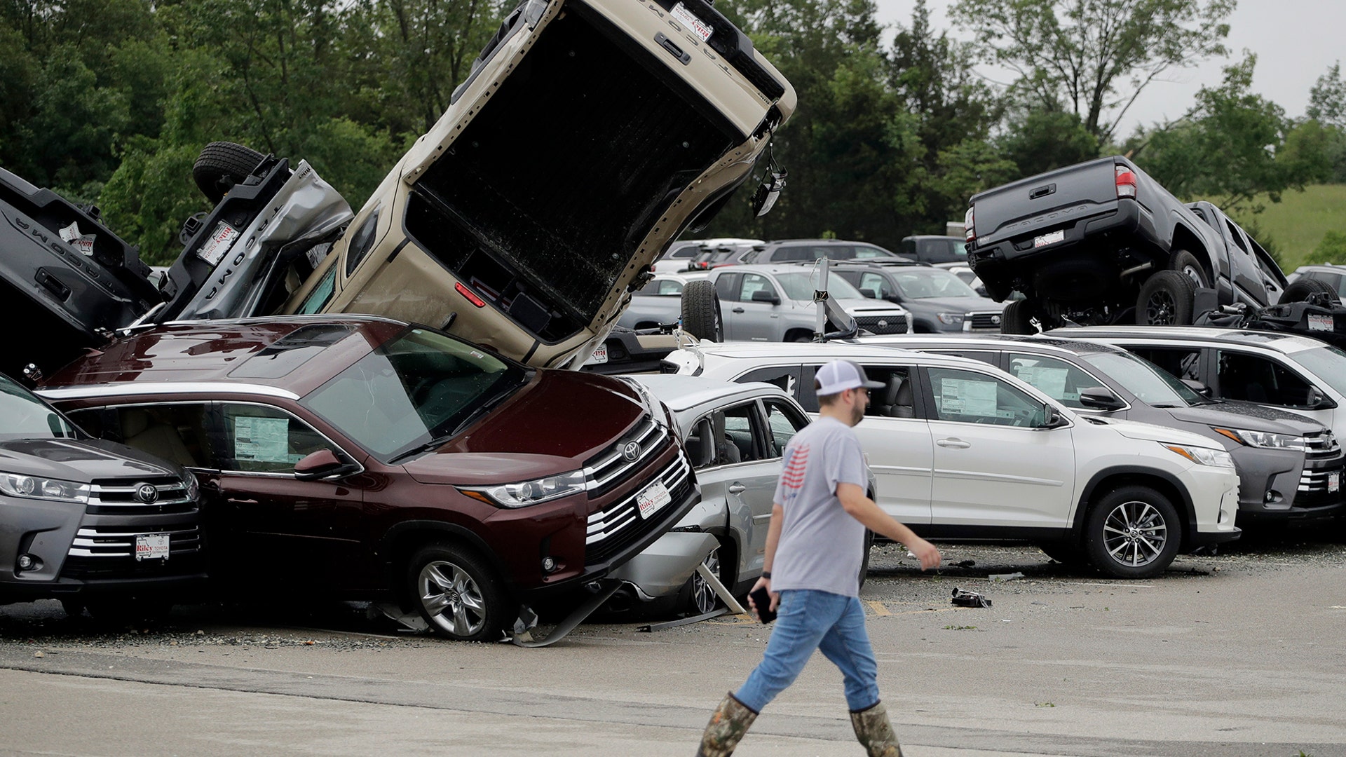 A worker walks past tornado-damaged Toyotas at a dealership in Jefferson City, Missouri, May 23, 2019.
