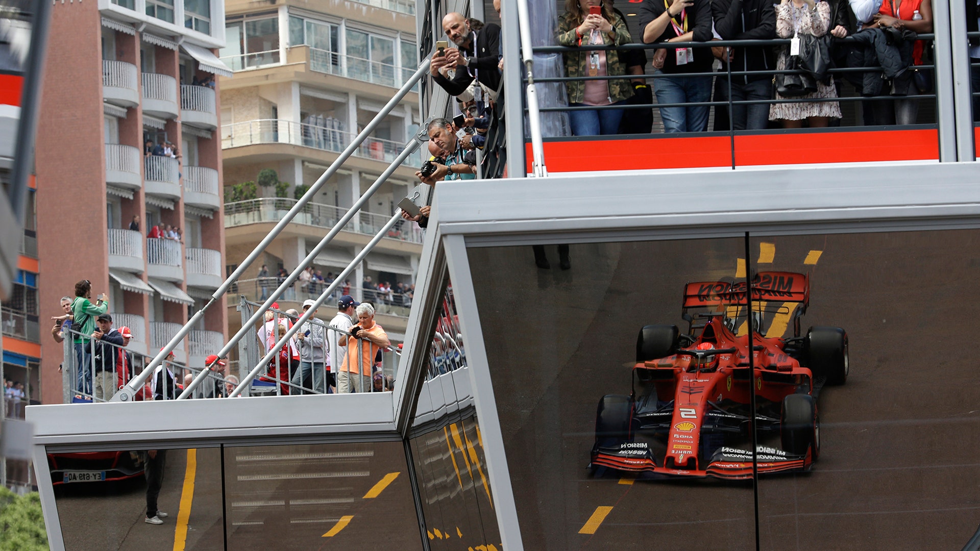 Ferrari driver Sebastian Vettel of Germany is reflected on the glass of the paddock during the second practice session at the Monaco racetrack, May 23, 2019.