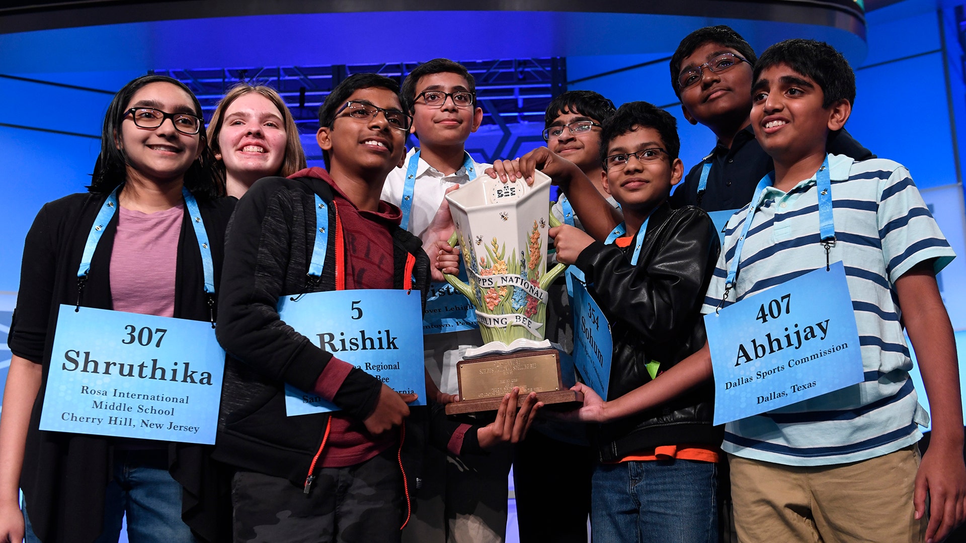 The eight co-champions of the 2019 Scripps National Spelling Bee, from left, Shruthika Padhy, 13, of Cherry Hill, N.J., Erin Howard, 14, of Huntsville, Ala., Rishik Gandhasri, 13, of San Jose, Calif., Christopher Serrao, 13, of Whitehouse Station, N.J., Saketh Sundar, 13, of Clarksville, Md., Sohum Sukhatankar, 13, of Dallas, Texas, Rohan Raja, 13, of Irving, Texas, and Abhijay Kodali, 12, of Flower Mound, Texas, hold the trophy at the end of the competition in Oxon Hill, Maryland, May 31, 2019. 