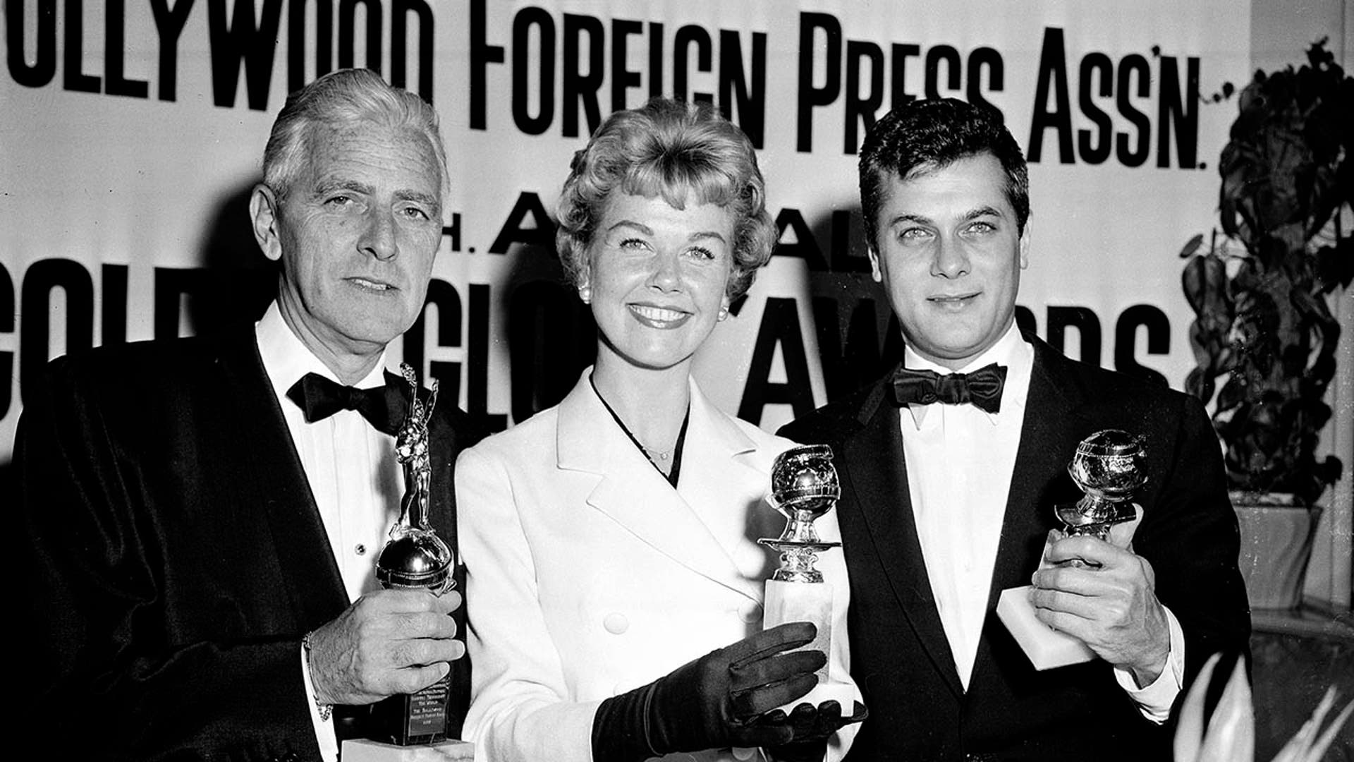 Doris Day, poses with Tony Curtis, right, and Buddy Adler at the Hollywood Foreign Press Association's annual awards dinner in the Cocoanut Grove in Los Angeles. Day, whose wholesome screen presence stood for a time of innocence in '60s films, has died, her foundation says. . (AP Photo, File)