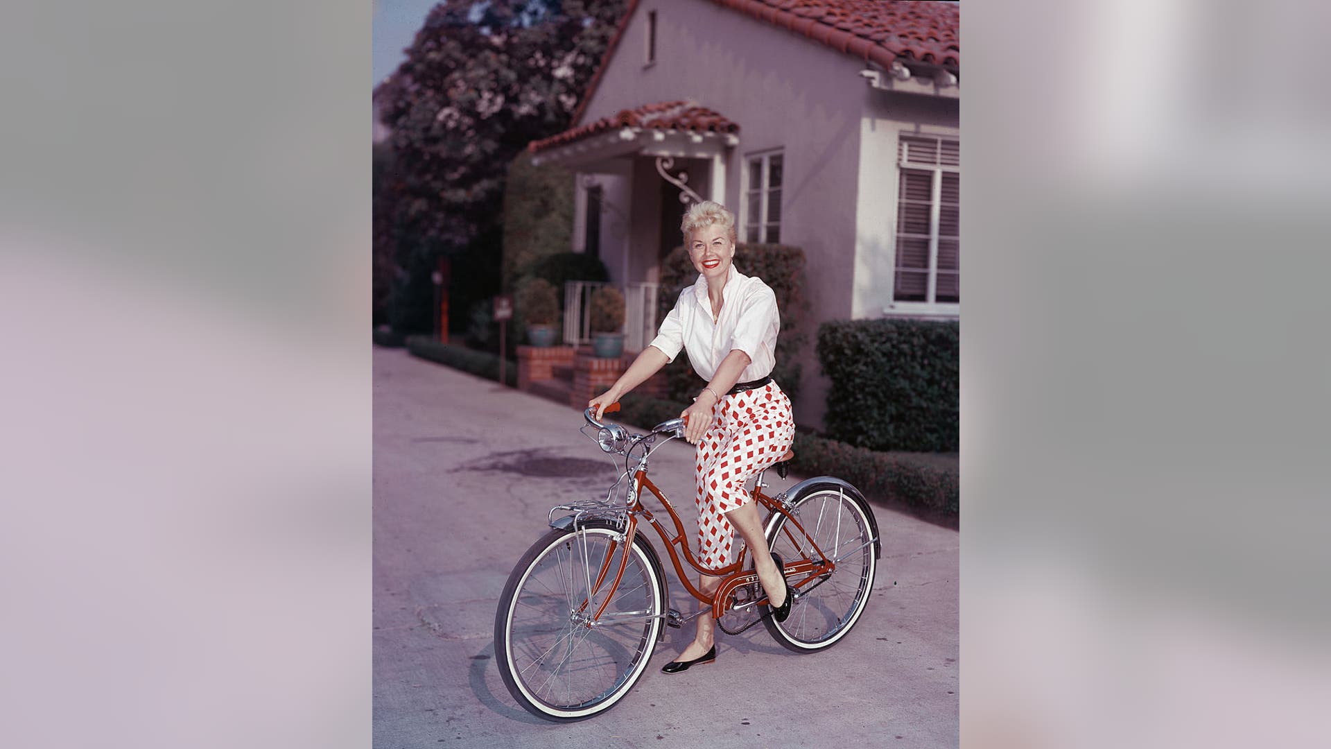 Doris Day poses on a red Schwinn bicycle in the late 1950s.