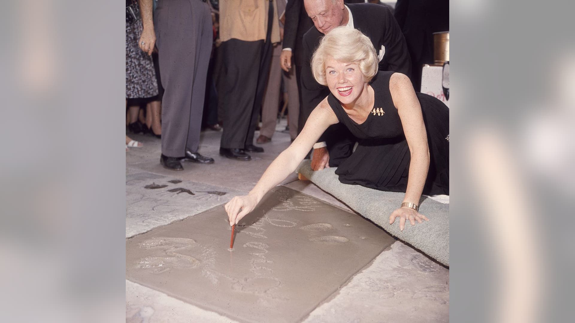 Doris Day signs her name in cement by her handprints, in front of Mann's (formerly Grauman's) Chinese Theater, on Hollywood Boulevard in January 1961.