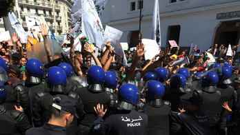 Algerians hold anti-government protest, jump on police vans