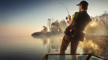 Fisherman dives in lake after line breaks, catches bass with bare hands