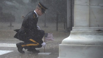 Soldier seen placing flag at Tomb of Unknown Soldier during torrential rain