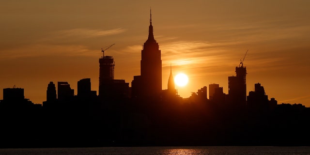 JERSEY CITY, NJ - MAY 25: The sun rises behind the Empire State Building, Chrysler Building and One Vanderbilt in New York City on May 25, 2019, as seen from Jersey City, New Jersey. (Photo by Gary Hershorn/Getty Images)