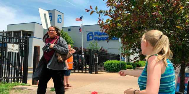 Anti-abortion activist Teresa Pettis, right, greets a passerby outside the Planned Parenthood clinic in St. Louis. last month. (AP Photo/Jim Salter, File)
