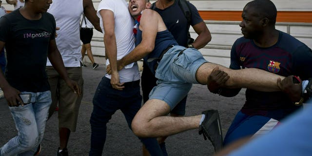 Cuban police detain a gay rights activist taking part in an unauthorized march in Havana, Cuba, Saturday, May 11, 2019. The march was organized largely using Cuba's new mobile internet, with gay-rights activists and groups of friends calling for a march over Facebook and WhatsApp after the government-run gay rights organization canceled a Saturday march.