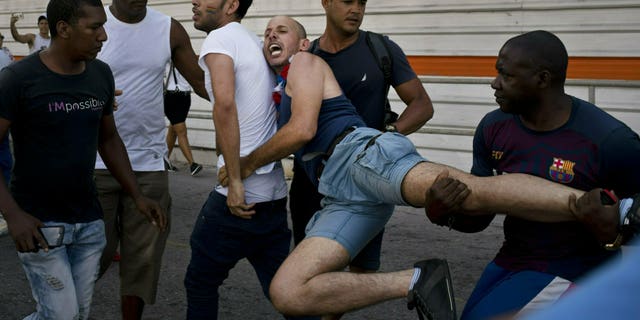 Cuban police detain a gay rights activist taking part in an unauthorized march in Havana, Cuba, Saturday, May 11, 2019. The march was organized largely using Cuba's new mobile internet, with gay-rights activists and groups of friends calling for a march over Facebook and WhatsApp after the government-run gay rights organization canceled a Saturday march.
