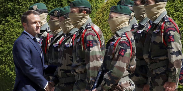 French President Emmanuel Macron shakes hands with special forces soldiers during a national tribute for late special forces soldiers Cedric de Pierrepont and Alain Bertoncello, who were killed in a night-time rescue of four foreign hostages including two French citizens in Burkina Faso last week, at the Invalides, in Paris, Tuesday, May 14, 2019. France is honoring two special forces officers killed in an operation that freed four hostages held in Burkina Faso.