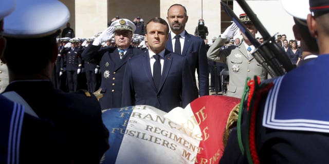 French President Emmanuel Macron honors the late special forces soldiers Cedric de Pierrepont and Alain Bertoncello, who were killed in a night-time rescue of four foreign hostages including two French citizens in Burkina Faso last week, during a national tribute at the Invalides, in Paris, Tuesday, May 14, 2019. France is honoring two special forces officers killed in an operation that freed four hostages held in Burkina Faso.