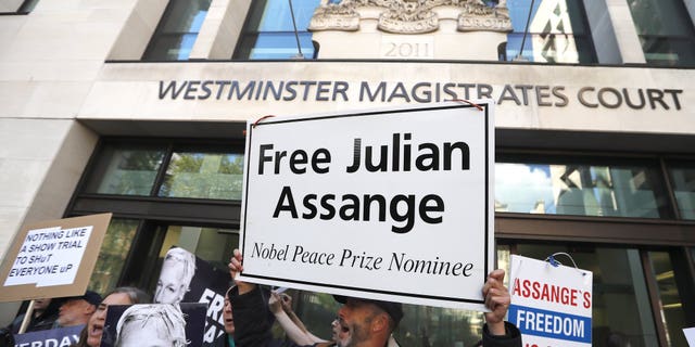 Protestors demonstrate at the entrance of Westminster Magistrates Court in London, Thursday, May 2, 2019, where WikiLeaks founder Julian Assange appeared by video link from prison. Assange is facing a court hearing over a U.S. request to extradite him for alleged computer hacking.