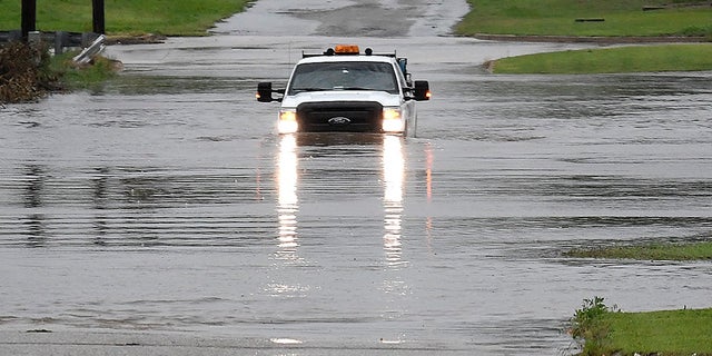 A pickup truck driving on a flooded street in Enid, Okla., on Monday. (Billy Hefton/The Enid News & Eagle via AP)