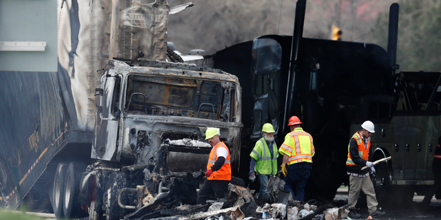 FILE - In this April 26, 2019, file photo, workers clear debris on Interstate 70 in Lakewood, Colo., from a pileup involving a semitrailer hauling lumber that killed four people. The driver of the truck told investigators that his brakes were not working. The Texas company that owns the semitrailer had two different trucks temporarily taken out of service for brake-related problems in the last year, according to federal safety records. (AP Photo/David Zalubowski, File)