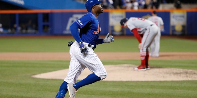 New York Mets' Rajai Davis, left, runs between third and home on his eighth-inning, three-run home run in the team's baseball game against the Washington Nationals, on Wednesday in New York, as Nationals relief pitcher Sean Doolittle, right, reacts on the mound. (Associated Press)