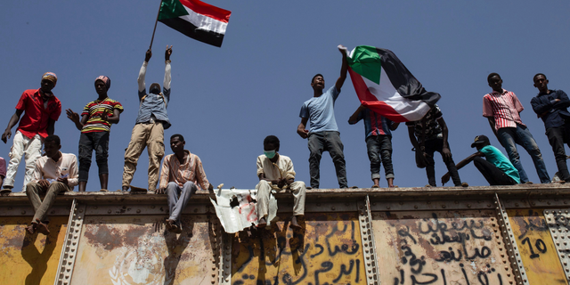 Sudanese protesters wave national flags at the sit-in outside the military headquarters, in Khartoum, Sudan, Thursday, May 2, 2019. Sudan's protesters are holding a mass rally to step up pressure on the military to hand power to civilians following last month's overthrow of President Omar al-Bashir. (AP Photos/Salih Basheer)