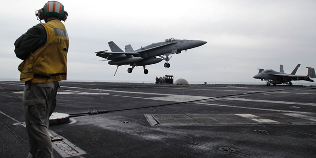 FILE - In this Feb. 13, 2012, file photo, a U.S. fighter jet lands on the USS Abraham Lincoln aircraft carrier during exercises in the Persian Gulf. The U.S. is dispatching the USS Abraham Lincoln and other military resources to the Middle East following “clear indications” that Iran and its proxy forces were preparing to possibly attack U.S. forces in the region, according to a defense official on May 5, 2019. (AP Photo/Hassan Ammar, File)
