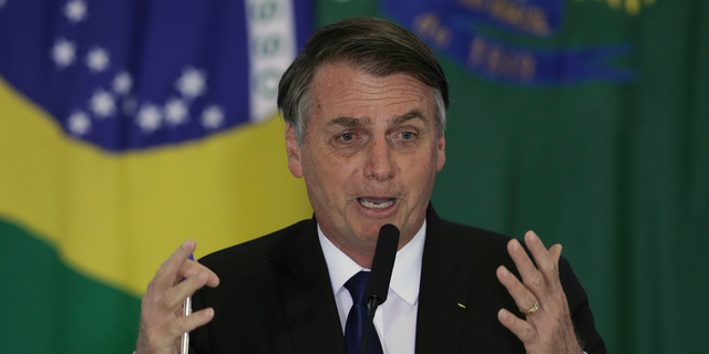 Brazil's President Jair Bolsonaro speaks during a ceremony where he signed a second decree that eases gun restrictions, during the signing ceremony at Planalto presidential palace in Brasilia, Brazil, Tuesday, May 7, 2019. The decree opens Brazil’s market to guns and ammunition made outside of Brazil according to a summary of the decree. Gun owners can now buy between 1,000 -5,000 rounds of ammunition per year depending on their license, up from 50 rounds. Lower-ranking military members can now carry guns after 10 years of service. (AP Photo/Eraldo Peres)