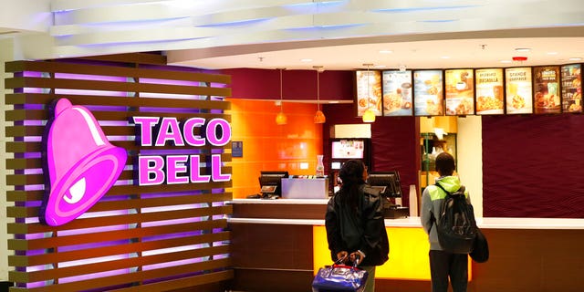 FILE: Travelers check out a menu at a Taco Bell restaurant located in Miami International Airport, Miami. (Associated Press)