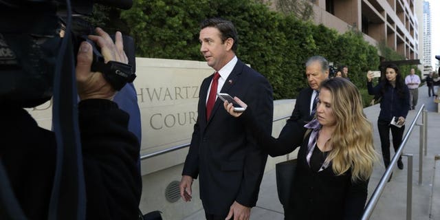 FILE - In this Dec. 3, 2018 file photo Republican Rep. Duncan Hunter, center, leaves court in San Diego..