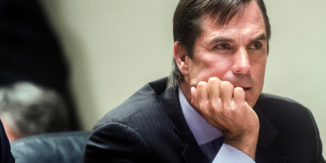 FILE - In this Aug. 20, 2018, file photo, Nick Lyon, director of the Michigan Department of Health and Human Services, listens closely as Genesee District Judge David J. Goggins gives his decision during Lyon's preliminary examination at Genesee District Court in Flint, Mich. Lawyers for Lyon are vigorously opposing an effort to put his Flint water criminal case on hold for six months, saying it's a sign of the prosecution team's "dysfunction." The attorney general's office says it needs a timeout so it can dig through 23 boxes of records found in the basement of a state building. (Jake May/The Flint Journal via AP, File)