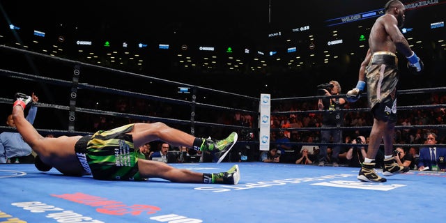 Deontay Wilder, right, knocks down Dominic Breazeale during the first round of the WBC heavyweight championship boxing match Saturday, May 18, 2019, in New York. Wilder won in the first round. (AP Photo/Frank Franklin II)