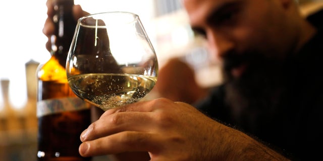 Craft brewer from Biratenu, the Jerusalem Beer Center, Shmuel Naky, right, pours beer during a press conference in Jerusalem, Wednesday, May 22, 2019. (AP Photo/Sebastian Scheiner)