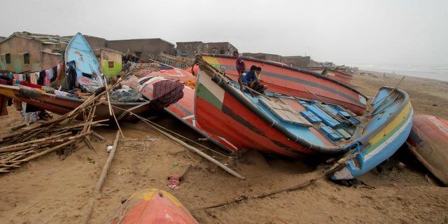 Children sit on a boat damaged by Cyclone Fani in the Penthakata fishing village of Puri, in the eastern Indian state of Orissa, Saturday, May 4, 2019. (AP Photo)