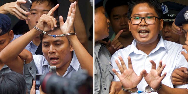 FILE: Reuters journalists Kyaw Soe Oo, left, and Wa Lone, are handcuffed as they are escorted by police out of a court in Yangon, Myanmar.