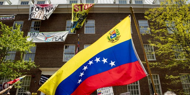 Pro-interim government opposition leader Juan Guaido, and pro-Nicolas Maduro supporters, separated by members of the uniformed Secret Service, rally outside of the Venezuelan Embassy in Washington, Tuesday, April 30, 2019. (AP Photo/Andrew Harnik)