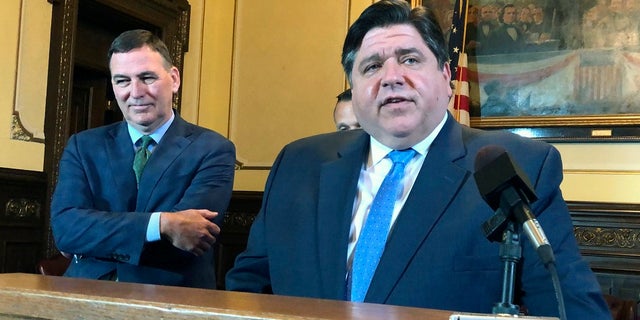 Illinois Gov. J.B. Pritzker, right, has made eliminating the state's flat tax a legislative priority. (AP Photo/John O'Connor)